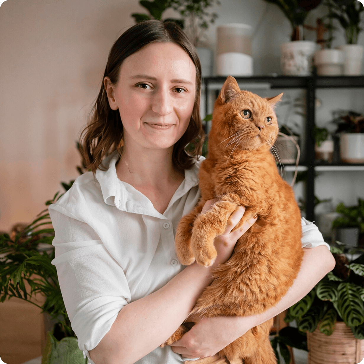 A lady holding her ginger cat