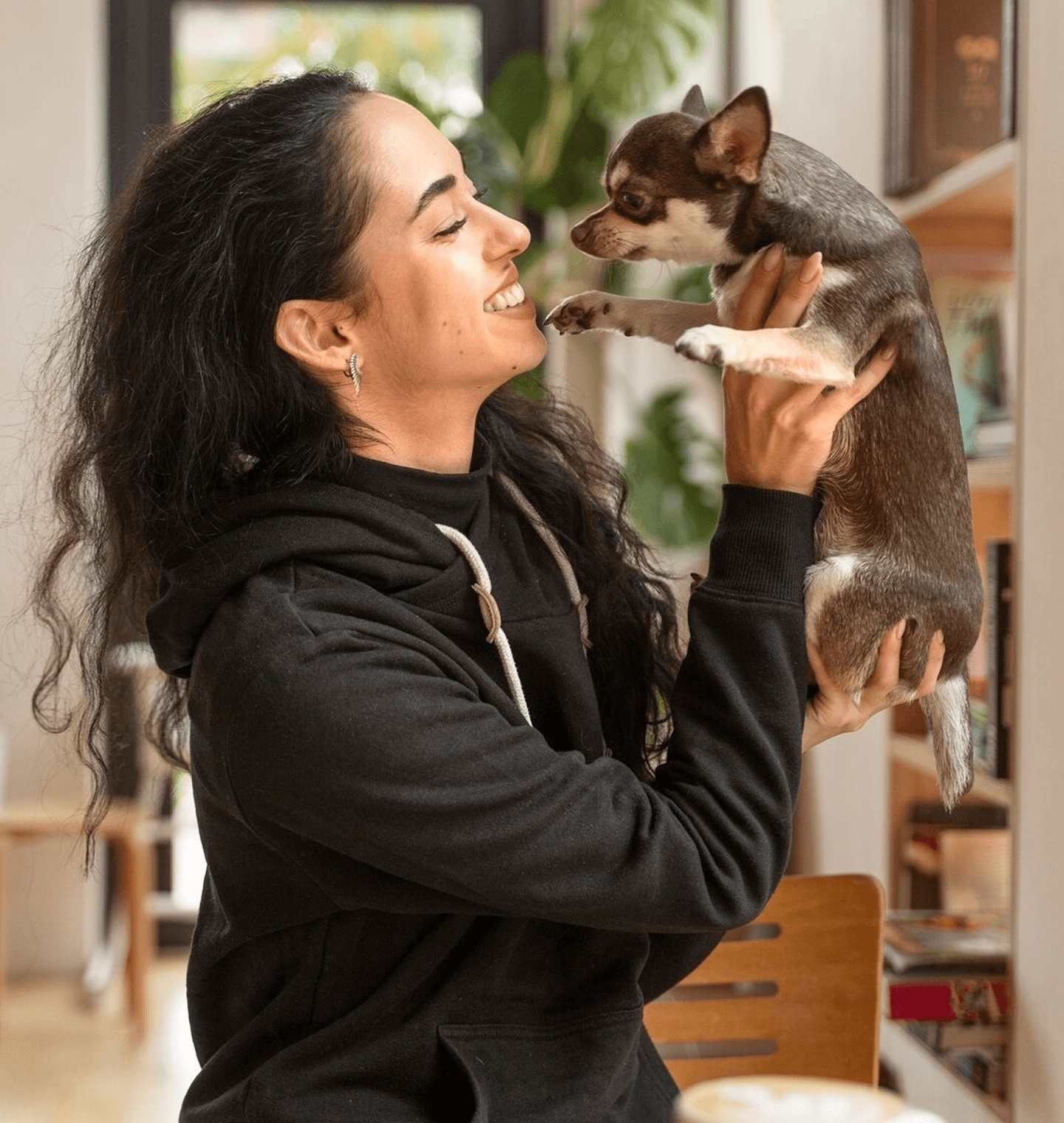 A lady playing with her chihuahua